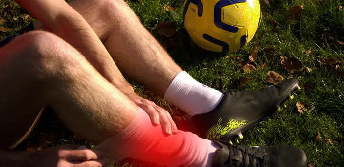 Footballer bandaging a sprained ankle